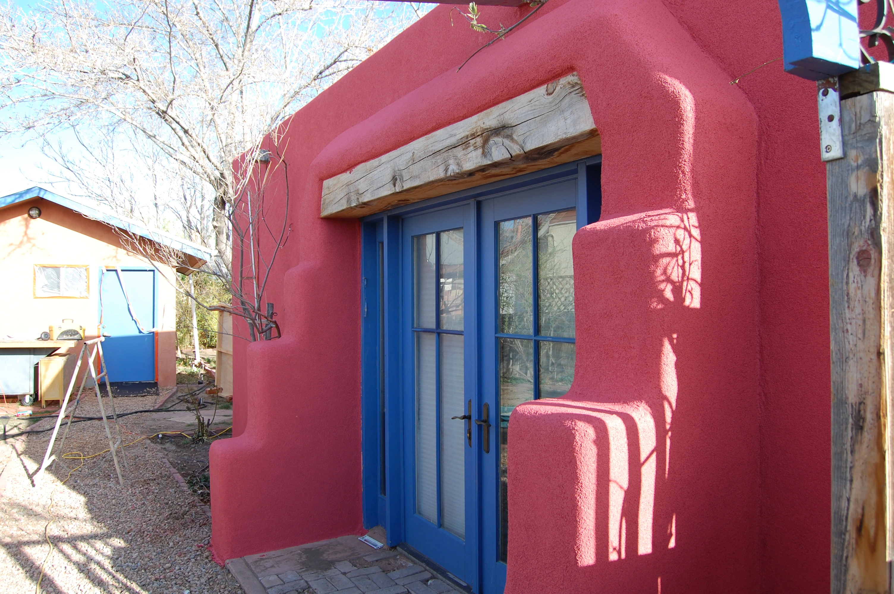 A vibrant red and blue door featuring a blue window, showcasing a striking color contrast.